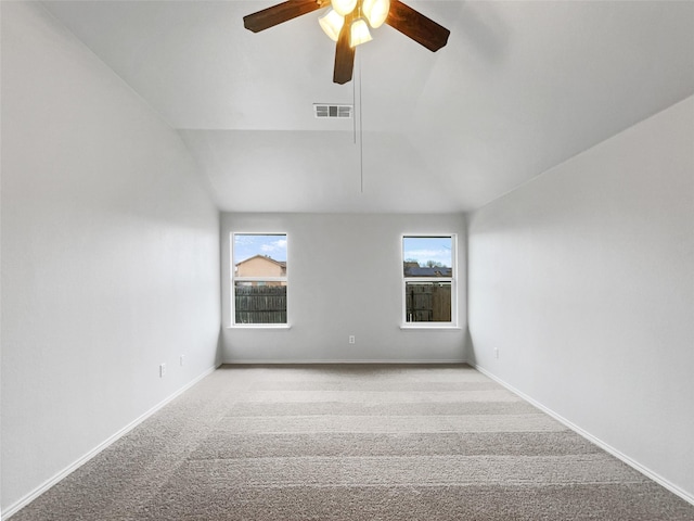 carpeted empty room featuring ceiling fan and lofted ceiling