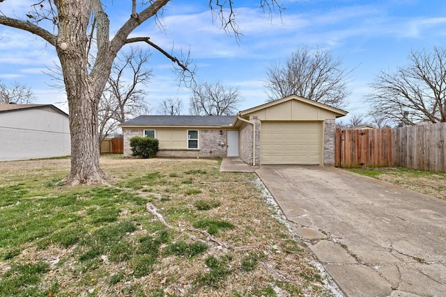 view of front of house featuring a garage, driveway, fence, and a front lawn