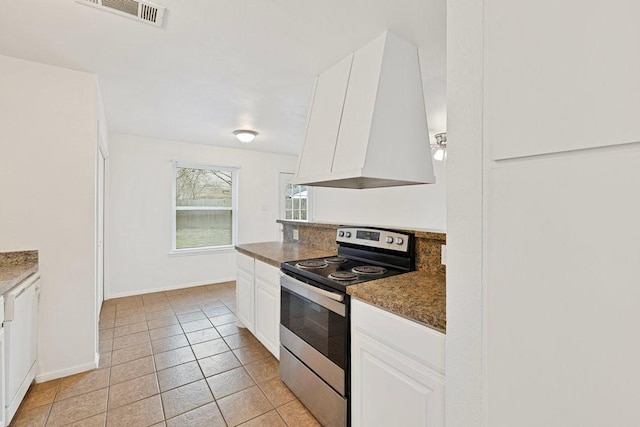 kitchen featuring light tile patterned floors, visible vents, island exhaust hood, stainless steel electric stove, and white cabinetry