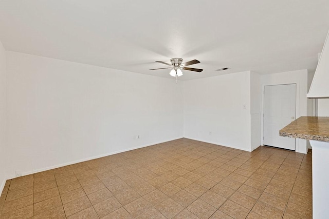 unfurnished room featuring visible vents, a ceiling fan, and baseboards