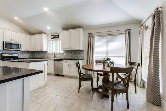 kitchen featuring lofted ceiling, appliances with stainless steel finishes, and white cabinets