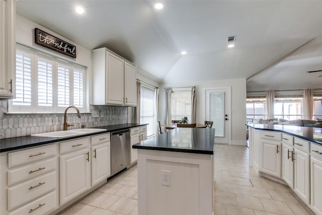 kitchen with sink, white cabinetry, a center island, dishwasher, and backsplash