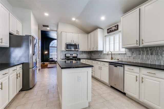 kitchen with appliances with stainless steel finishes, sink, a kitchen island, and white cabinets