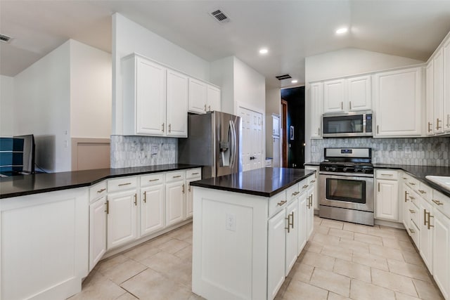 kitchen with white cabinetry, backsplash, stainless steel appliances, and a center island