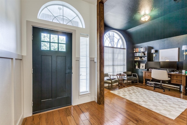 entrance foyer featuring high vaulted ceiling and hardwood / wood-style floors