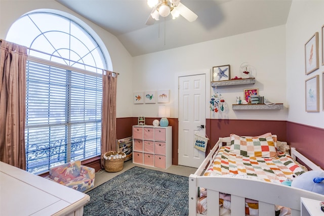 bedroom featuring ceiling fan, carpet floors, vaulted ceiling, and multiple windows