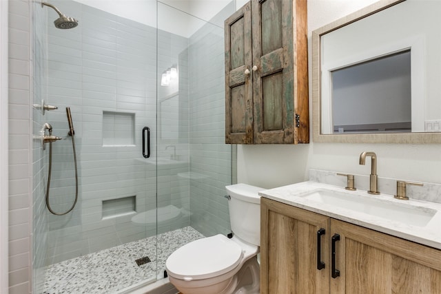 bathroom featuring vanity, toilet, and an enclosed shower