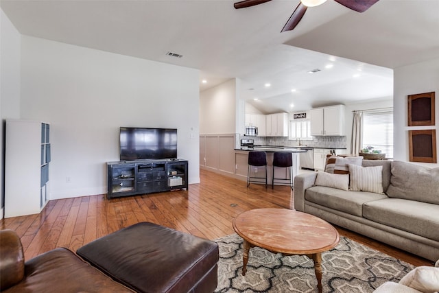 living room featuring vaulted ceiling, sink, ceiling fan, and light hardwood / wood-style floors