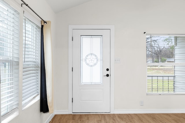 foyer entrance featuring lofted ceiling and light hardwood / wood-style floors