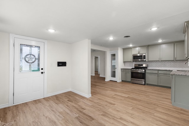 kitchen featuring appliances with stainless steel finishes, sink, light hardwood / wood-style floors, and gray cabinetry