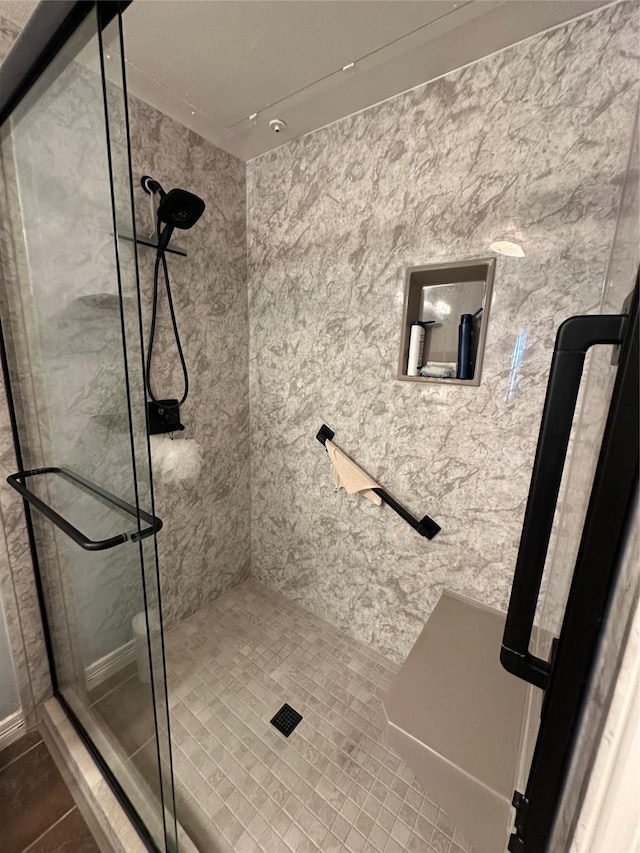 bathroom with tiled shower and tile patterned floors