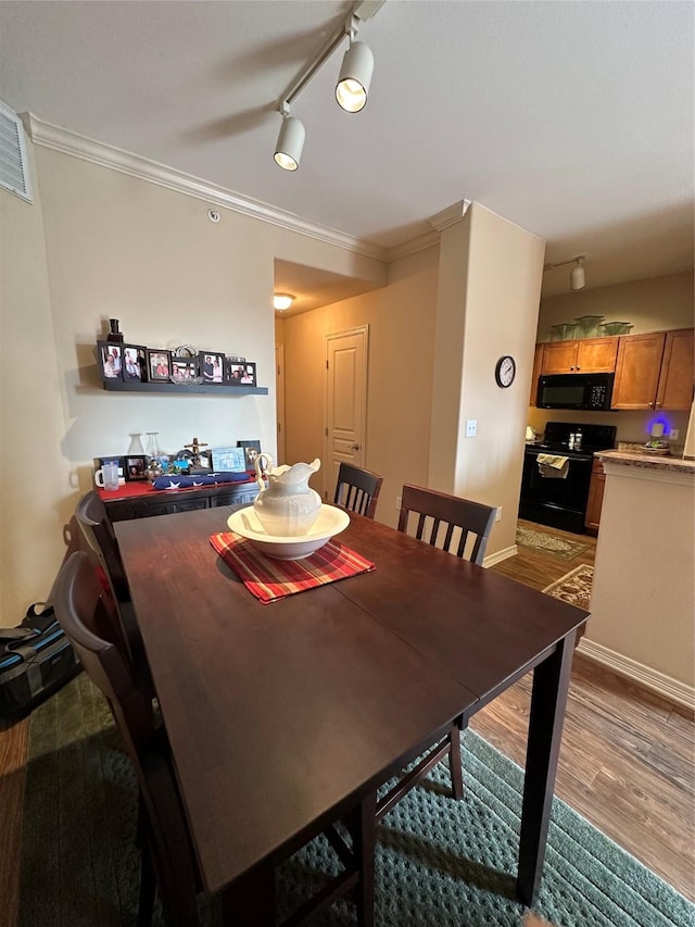 dining area with hardwood / wood-style floors and ornamental molding