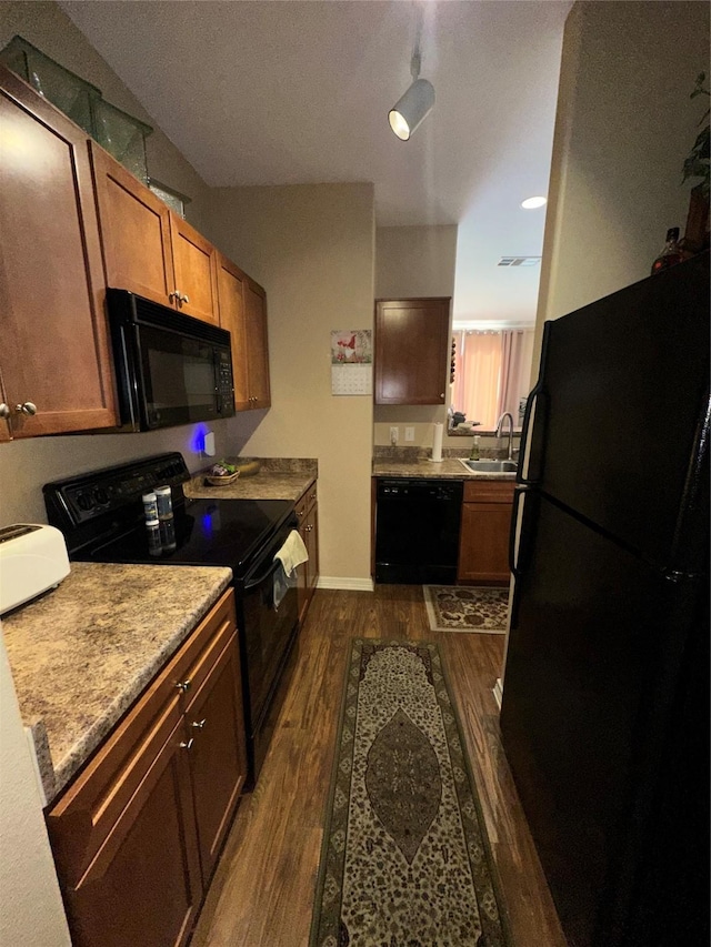 kitchen with dark hardwood / wood-style flooring, sink, and black appliances