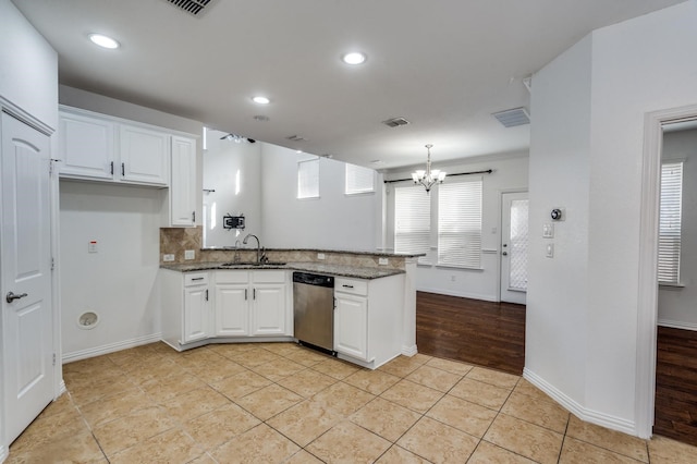 kitchen featuring white cabinetry, dark stone countertops, sink, and stainless steel dishwasher