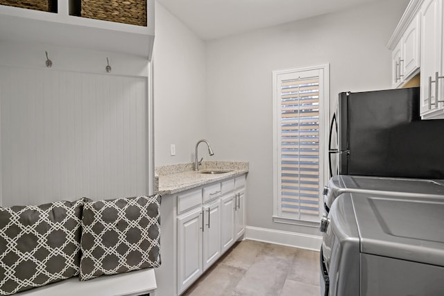 laundry room with sink, light tile patterned floors, and washing machine and dryer