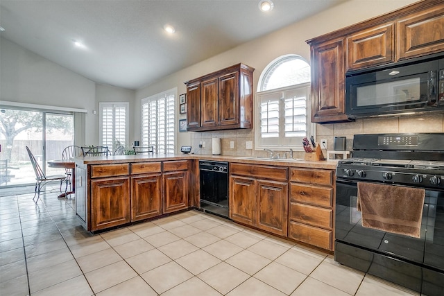 kitchen featuring black appliances, lofted ceiling, sink, backsplash, and kitchen peninsula