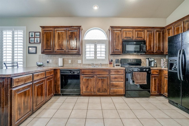 kitchen with black appliances, sink, backsplash, light tile patterned floors, and kitchen peninsula