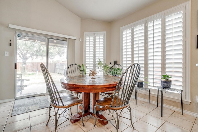 dining area featuring lofted ceiling and light tile patterned floors