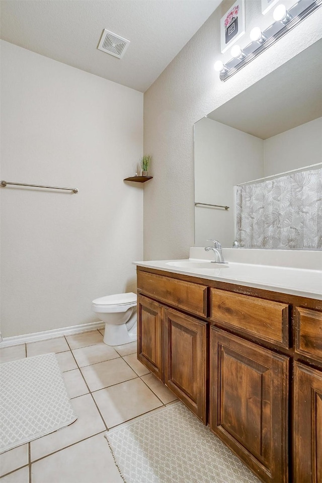 bathroom with vanity, tile patterned floors, and toilet