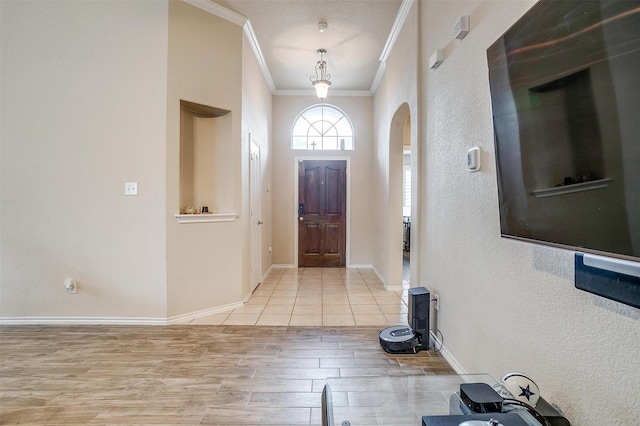 foyer featuring ornamental molding and light hardwood / wood-style floors