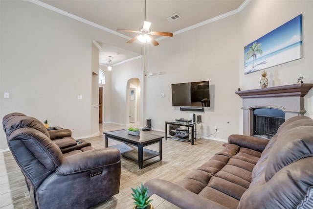 living room with crown molding, ceiling fan, and light wood-type flooring