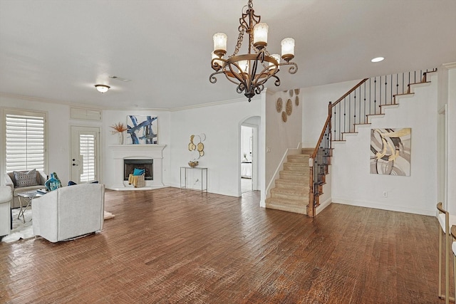 living room with stairway, a fireplace with raised hearth, crown molding, and wood finished floors