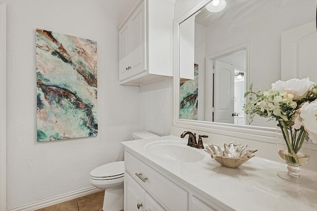 half bath with toilet, vanity, and tile patterned flooring