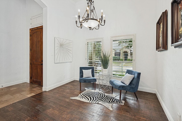 living area with wood finished floors, baseboards, and a chandelier