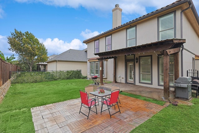 rear view of property featuring stucco siding, a lawn, a fenced backyard, a chimney, and a patio area