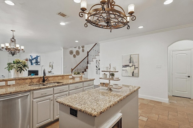 kitchen with visible vents, stainless steel dishwasher, an inviting chandelier, stone tile flooring, and a sink