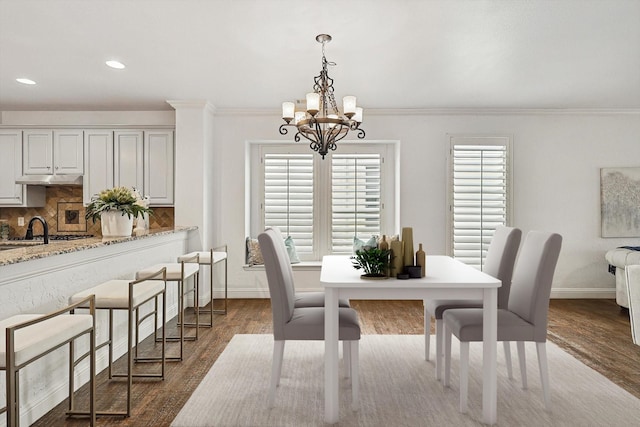 dining area featuring baseboards, dark wood finished floors, ornamental molding, recessed lighting, and an inviting chandelier