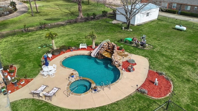 view of swimming pool featuring an outbuilding, a water slide, a lawn, and a storage unit