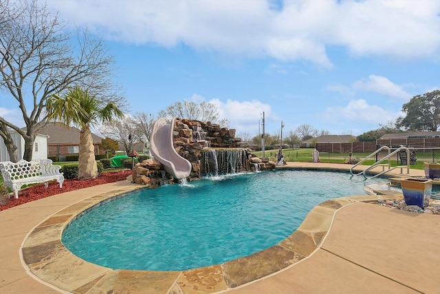 view of swimming pool with a water slide, fence, and a fenced in pool