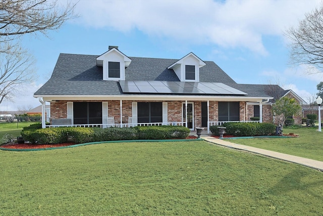 view of front of property featuring a porch, brick siding, and a front lawn