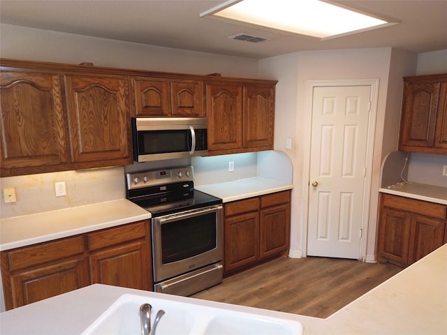 kitchen with dark hardwood / wood-style flooring, sink, and appliances with stainless steel finishes