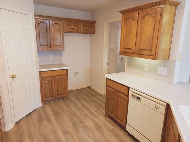 kitchen with sink, white dishwasher, and light hardwood / wood-style floors