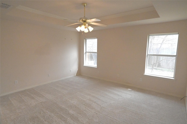 unfurnished room featuring crown molding, ceiling fan, a raised ceiling, and light carpet