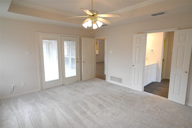 spare room with crown molding, carpet flooring, a tray ceiling, and ceiling fan