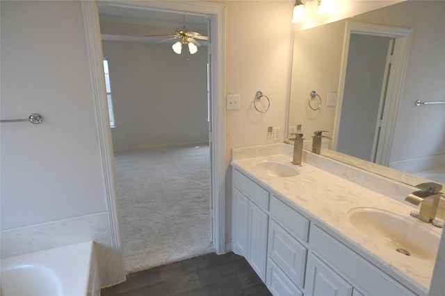 bathroom with vanity, a bathtub, and ceiling fan