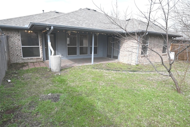 rear view of house featuring a yard, central AC, and a patio area