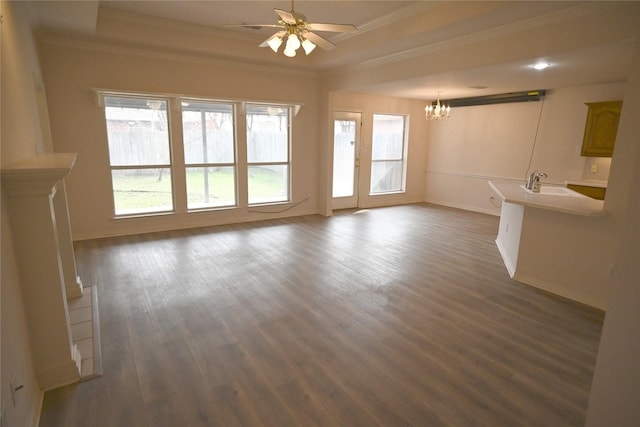 unfurnished living room featuring sink, crown molding, a tray ceiling, dark hardwood / wood-style flooring, and ceiling fan with notable chandelier