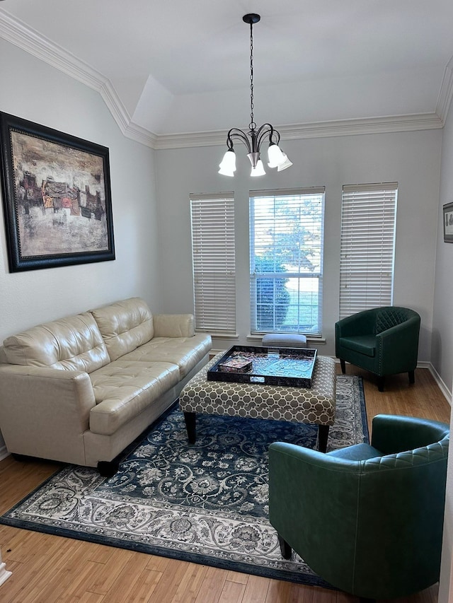 living room featuring wood-type flooring, ornamental molding, and a notable chandelier