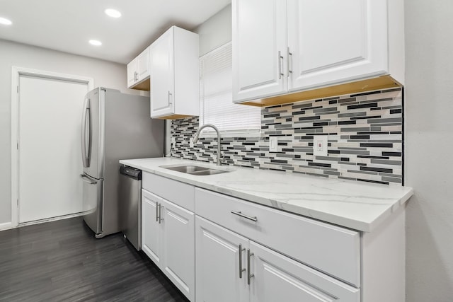 kitchen featuring sink, light stone counters, dishwasher, white cabinets, and backsplash