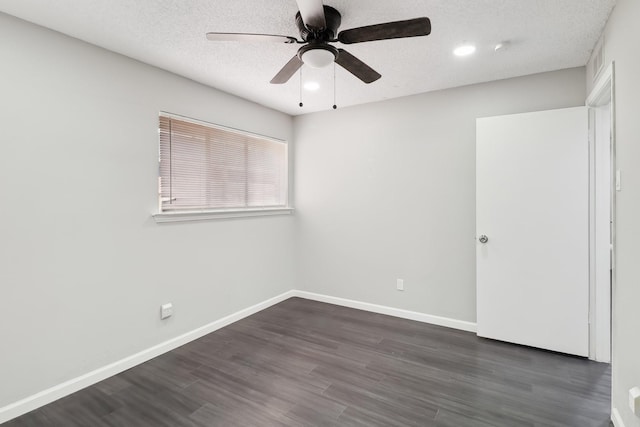 empty room featuring ceiling fan, dark wood-type flooring, and a textured ceiling