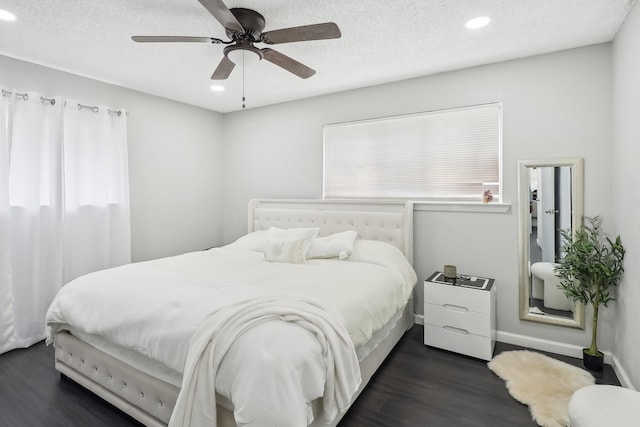 bedroom with ceiling fan, a textured ceiling, and dark hardwood / wood-style flooring