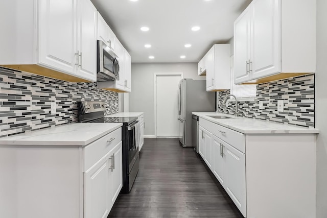 kitchen featuring light stone counters, stainless steel appliances, sink, and white cabinets