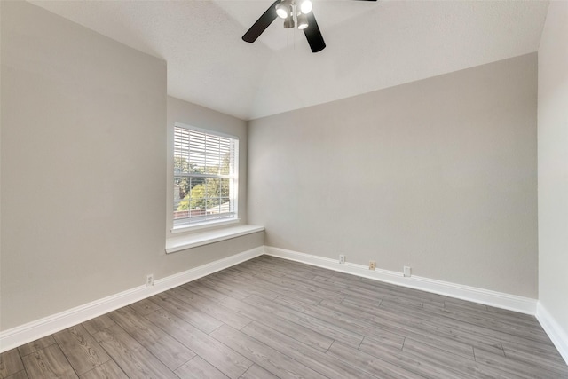 unfurnished room with vaulted ceiling, ceiling fan, and light wood-type flooring