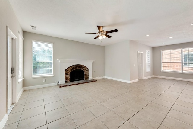 unfurnished living room featuring a wealth of natural light, a fireplace, and light tile patterned flooring