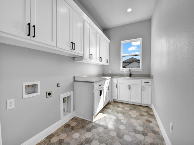 laundry area featuring electric dryer hookup, sink, hookup for a washing machine, and cabinets