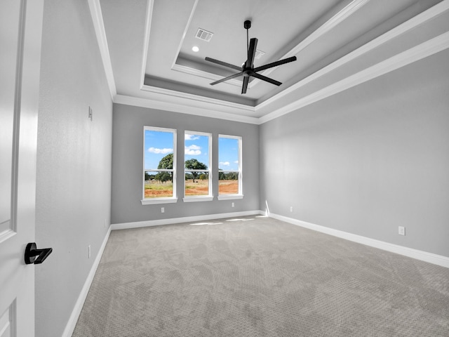 unfurnished room with ceiling fan, ornamental molding, a tray ceiling, and light carpet